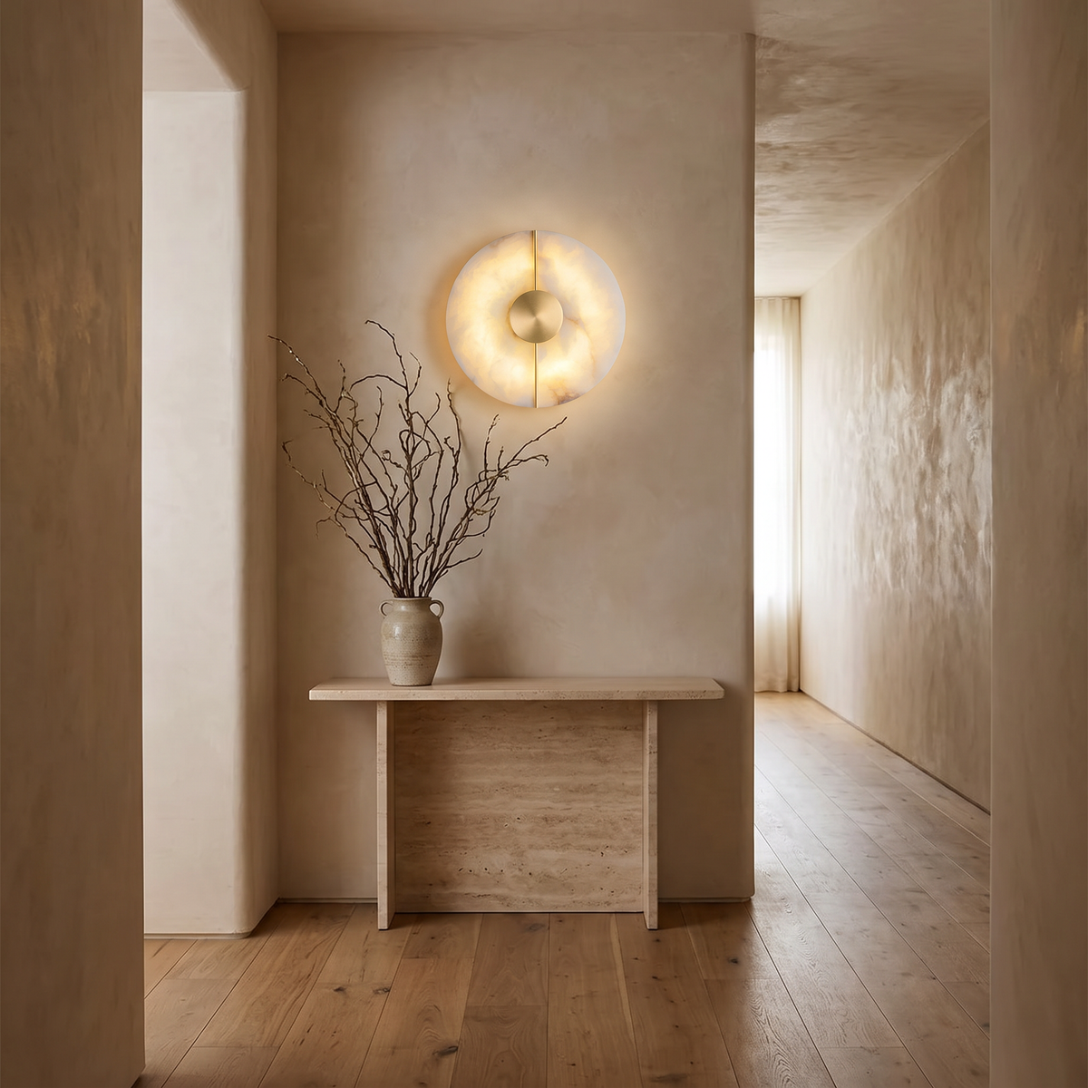 Avebury alabaster wall light above a travertine console in a hallway