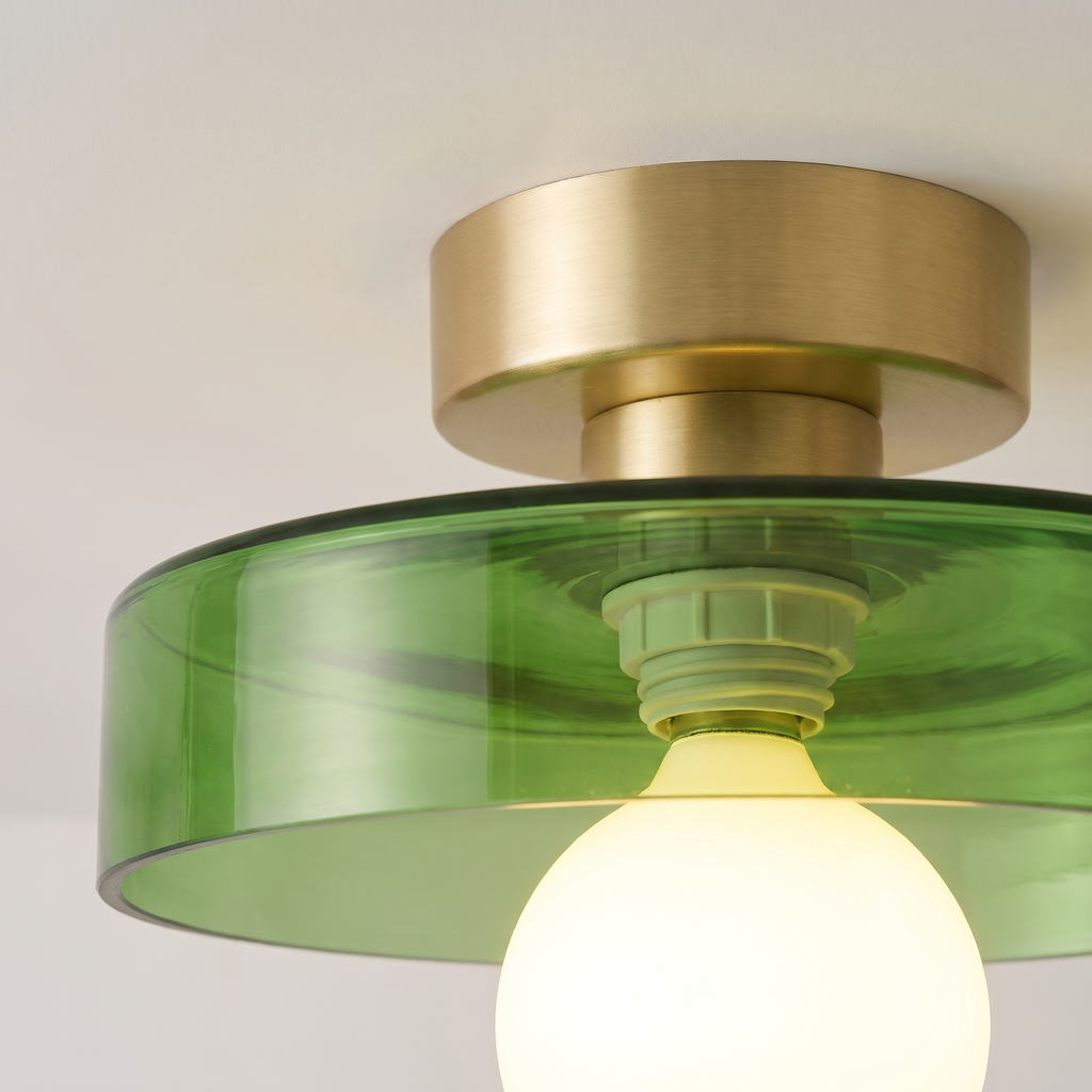 Close up of the Bawdsey green glass disc, brass canopy and globe bulb, lit