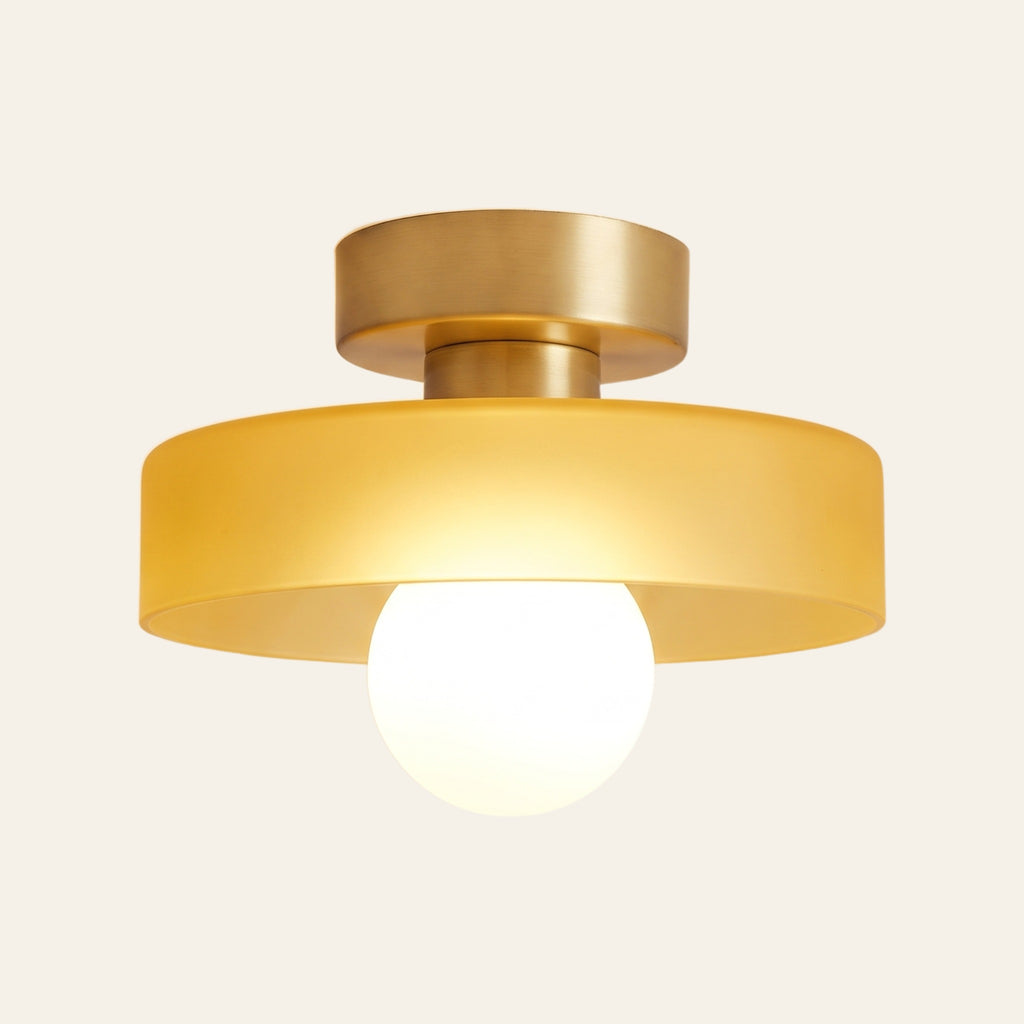 Bawdsey mid century flush ceiling light, honey glass disc on a brass canopy with a globe bulb, cream background