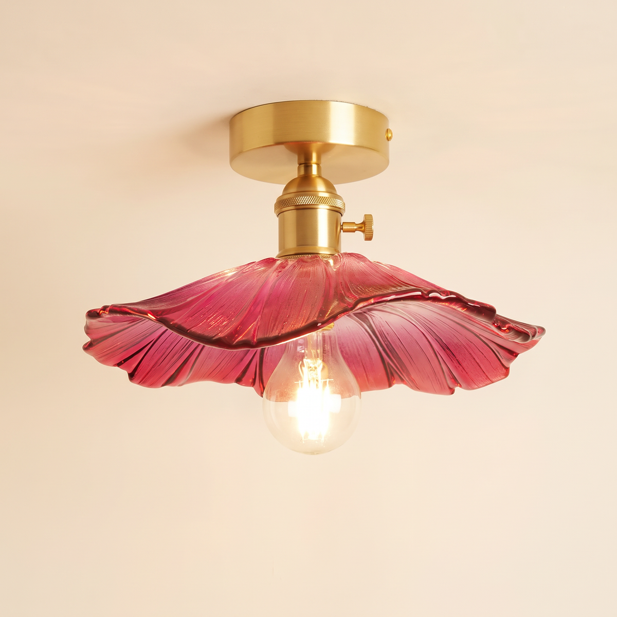 Benhall 28 cm semi flush ceiling light with a raspberry pink sunflower glass shade on a brass fitting, cream background