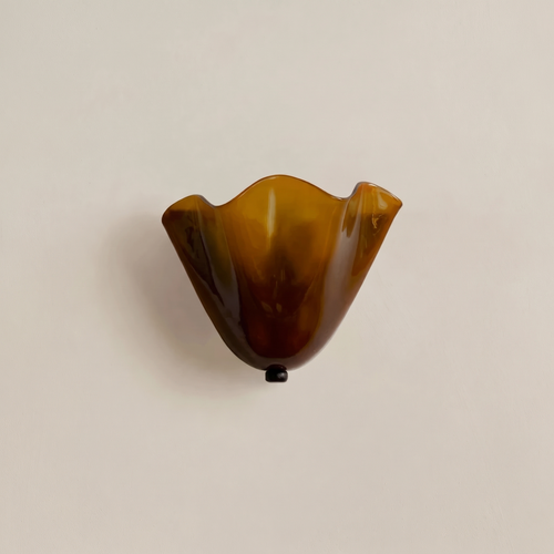 Blythburgh wall light, a folded handkerchief shade of honey amber glass with a waved rim, on a cream wall