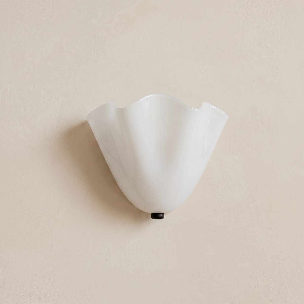 Blythburgh wall light, a folded handkerchief shade of milky opal glass with a waved rim, on a cream wall