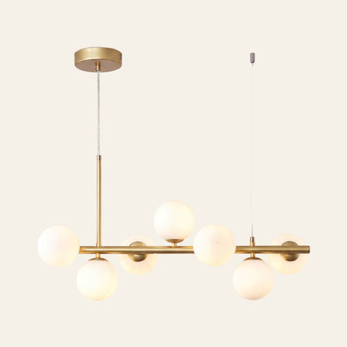 Brandeston linear chandelier with seven milky opal glass globes on a 65 cm gold bar, cream background