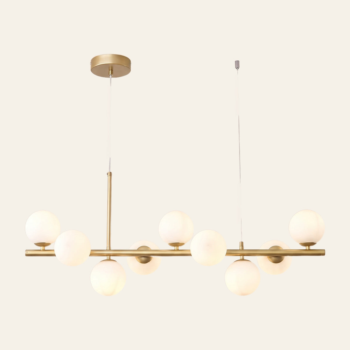 Brandeston linear chandelier with nine milky opal glass globes on an 83 cm gold bar, cream background