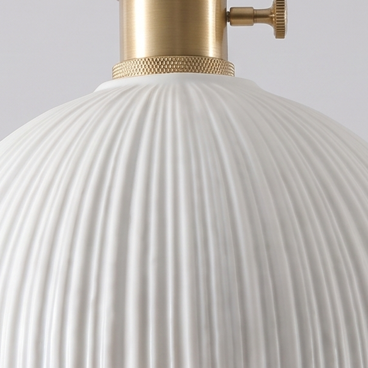 Close up of the fine ribs of the matte white Brantham ceramic shade and its brass holder