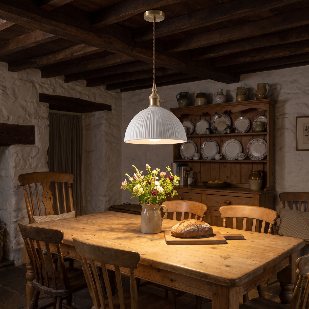 A lit Brantham ribbed dome pendant light over a farmhouse dining table