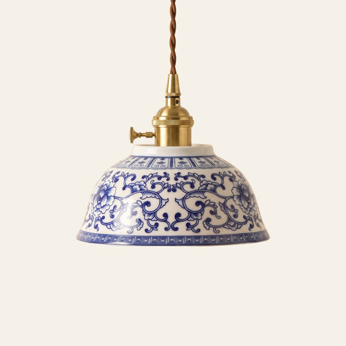 Bungay pendant light, an 18 cm blue and white ceramic bowl with a cobalt flower and scroll pattern on a brass finish holder with a turn switch, lit, cream background