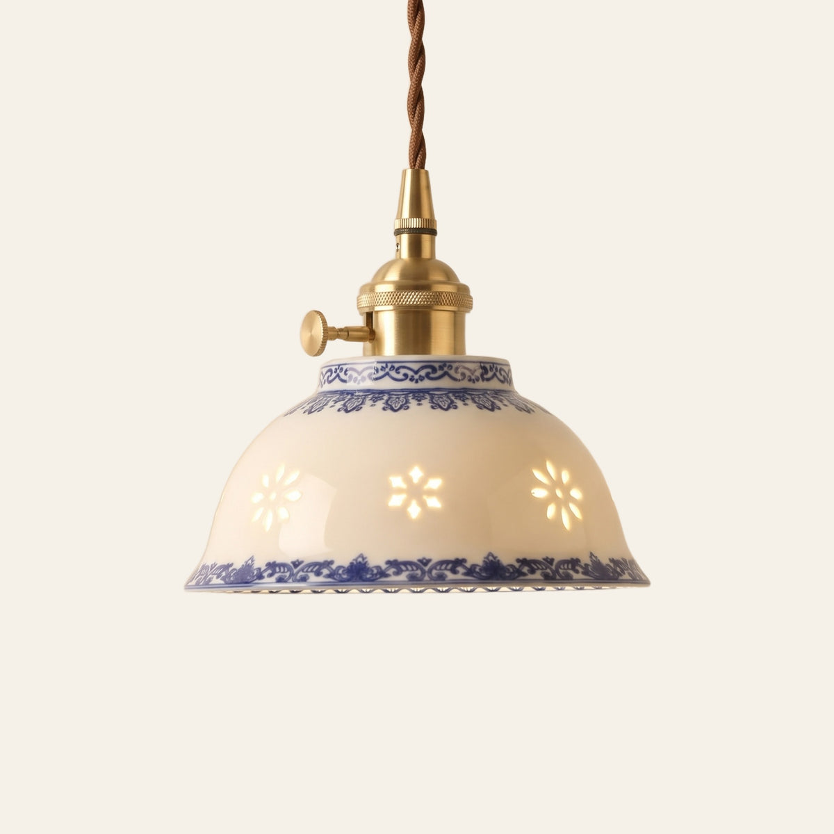 Bungay pendant light, a 15 cm white ceramic bowl with glowing translucent rice grain motifs and blue bands on a brass finish holder, lit, cream background