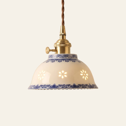 Bungay pendant light, a 15 cm white ceramic bowl with glowing translucent rice grain motifs and blue bands on a brass finish holder, lit, cream background