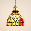 Bures stained glass pendant light in the floral design, lit, cream background
