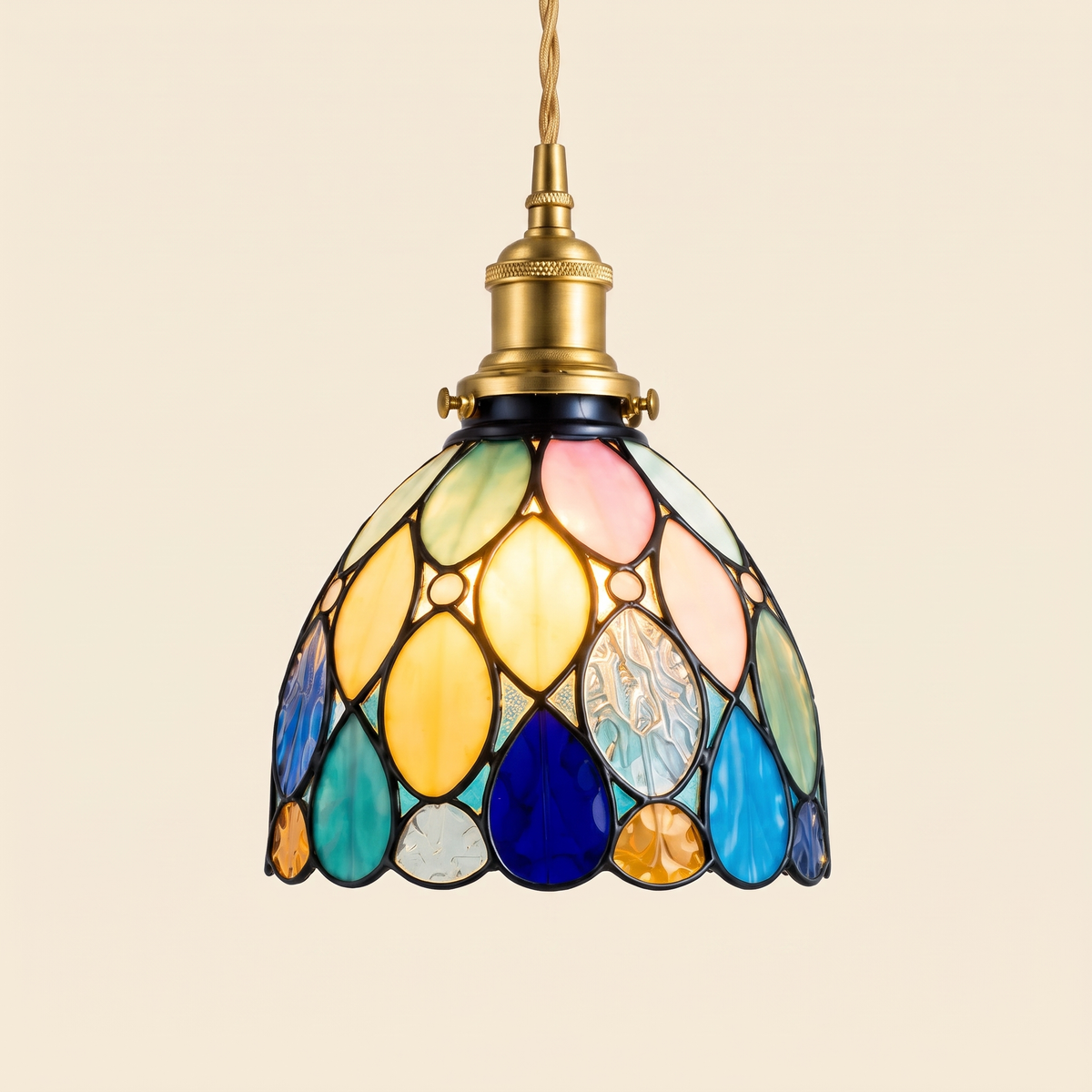 Bures stained glass pendant light in the teardrop design, lit, cream background