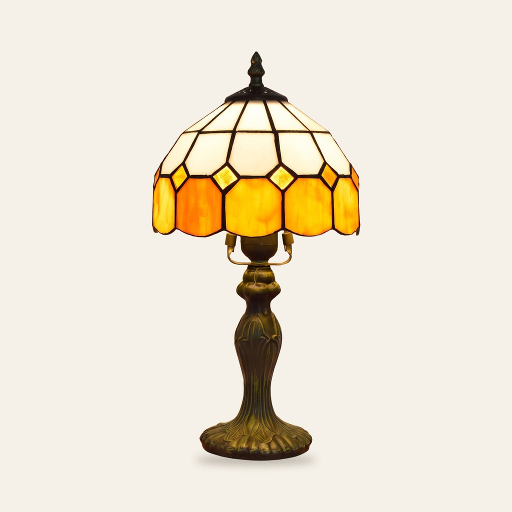 Cavendish stained glass table lamp with an ivory and amber leaded glass shade on a bronze finish base, cream background