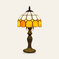Cavendish stained glass table lamp with an ivory and amber leaded glass shade on a bronze finish base, cream background
