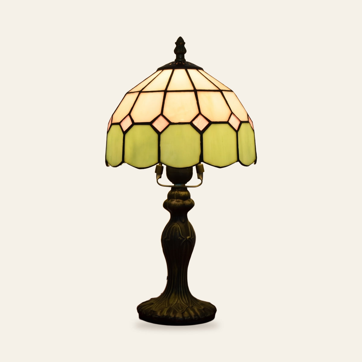 Cavendish stained glass table lamp with an ivory and green leaded glass shade on a bronze finish base, cream background