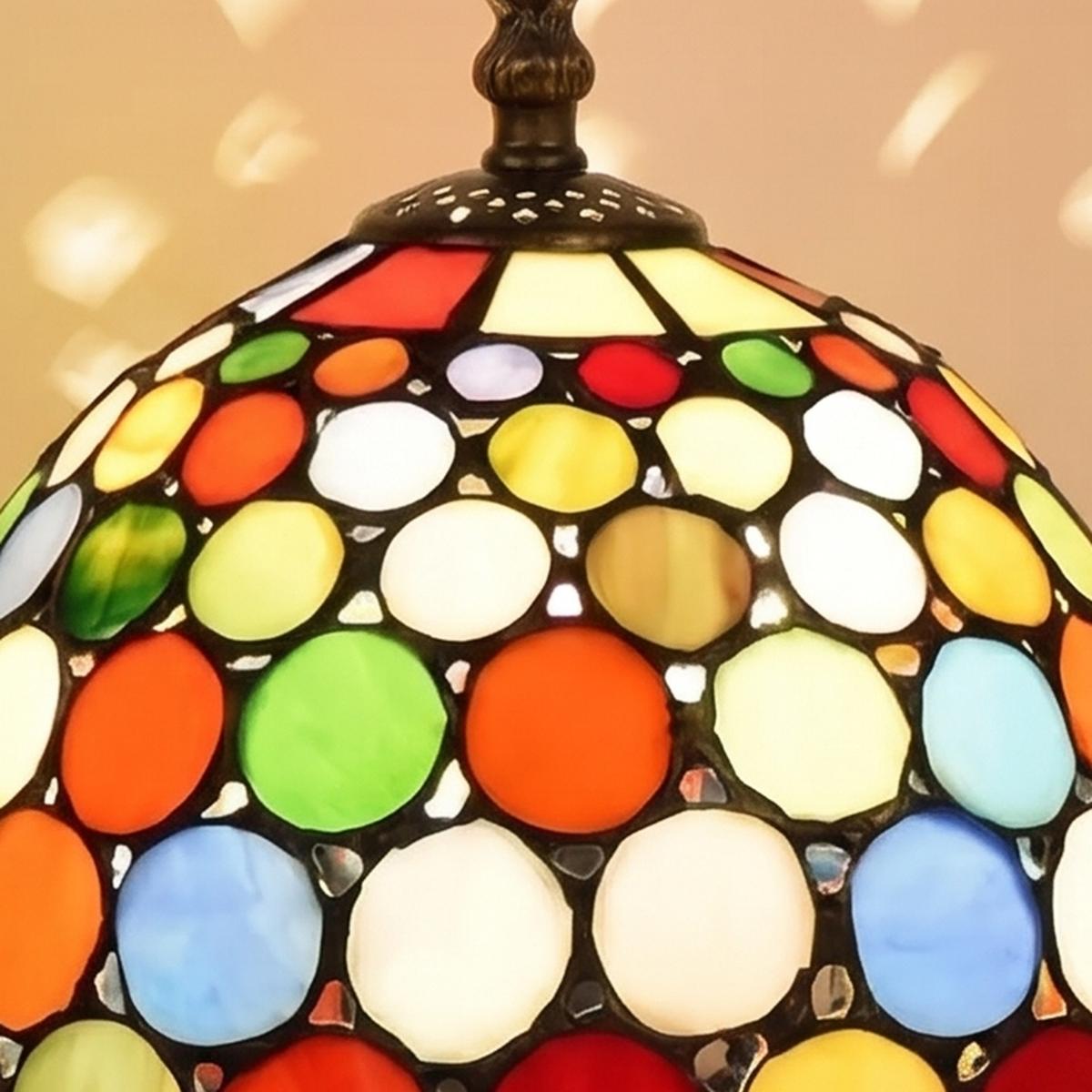 Close up of the round coloured glass jewels of the Chelsworth shade glowing warm