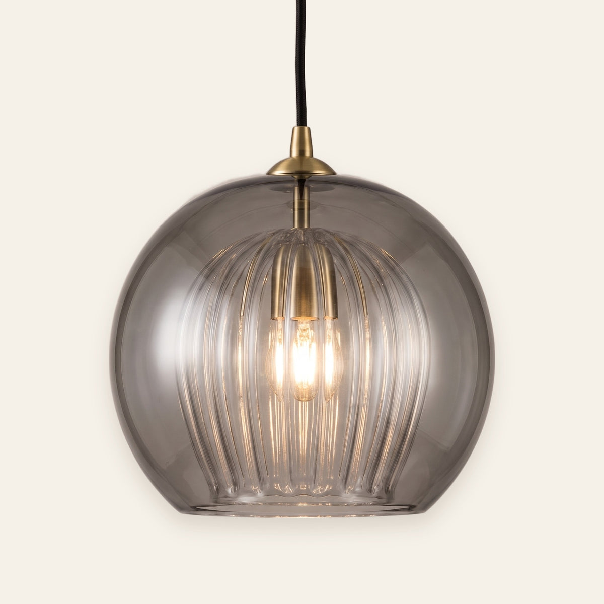 Corran smoked glass double globe pendant with brass cap, cream background