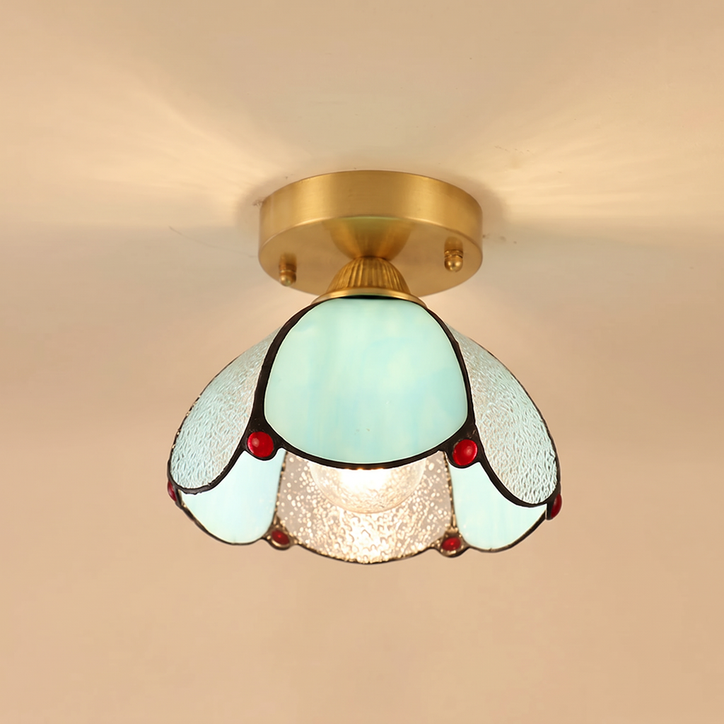 Darsham stained glass flush ceiling light with aqua and clear seeded glass petals and red glass jewels on a brass plate, cream background