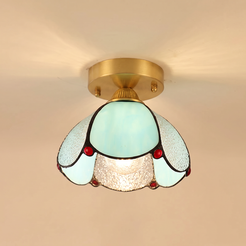 Darsham stained glass flush ceiling light with aqua and clear seeded glass petals and red glass jewels on a brass plate, cream background