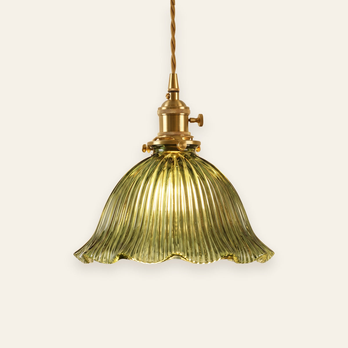 Dedham green fluted glass bell pendant light with a brass lamp holder, on a cream background