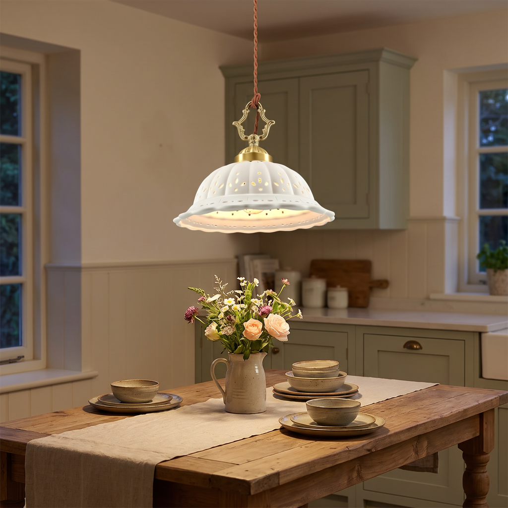 A lit Dennington pierced ceramic pendant over a farmhouse kitchen table