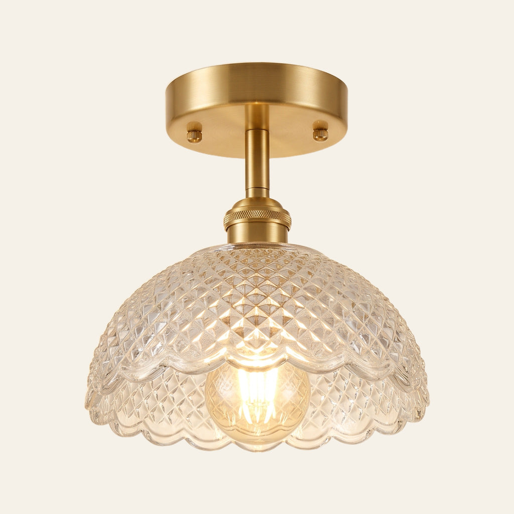Dunwich ceiling light with a clear diamond cut pressed glass shade on a brass rod, lit