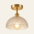 Dunwich ceiling light with a clear diamond cut pressed glass shade on a brass rod, lit
