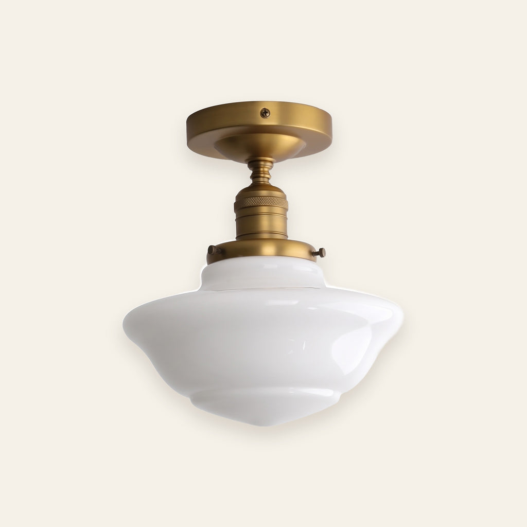 Ely milk glass semi flush ceiling light in antique brass finish on a cream background