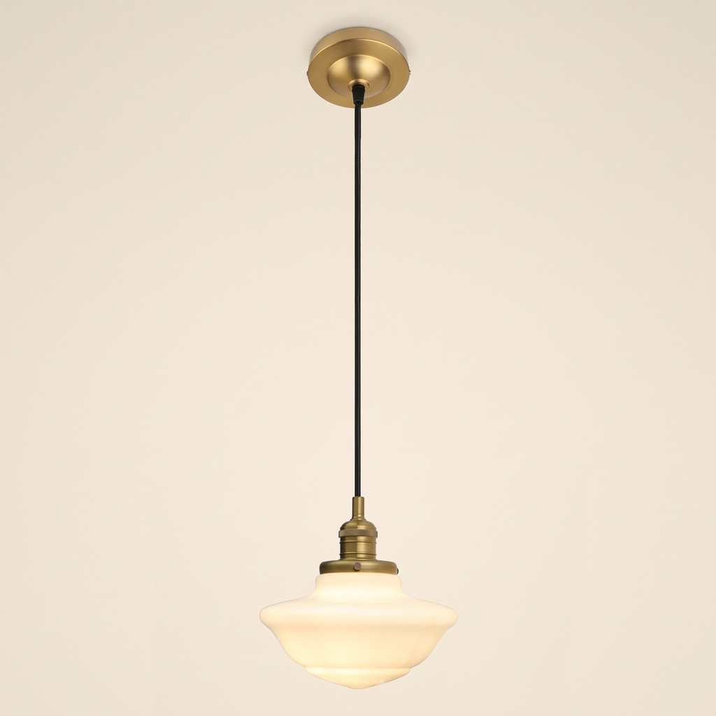 Ely pendant light with a stepped opal milk glass schoolhouse shade on a black cord, antique brass lamp holder and ceiling plate, cream background