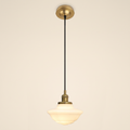 Ely pendant light with a stepped opal milk glass schoolhouse shade on a black cord, antique brass lamp holder and ceiling plate, cream background