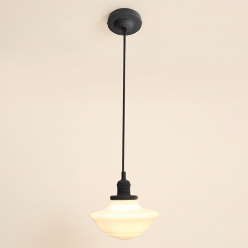 Ely pendant light with a stepped opal milk glass schoolhouse shade on a black cord, black lamp holder and ceiling plate, cream background