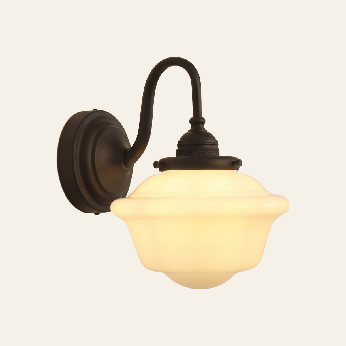 Ely swan neck wall light in matt black with a stepped opal milk glass schoolhouse shade, lit, cream background