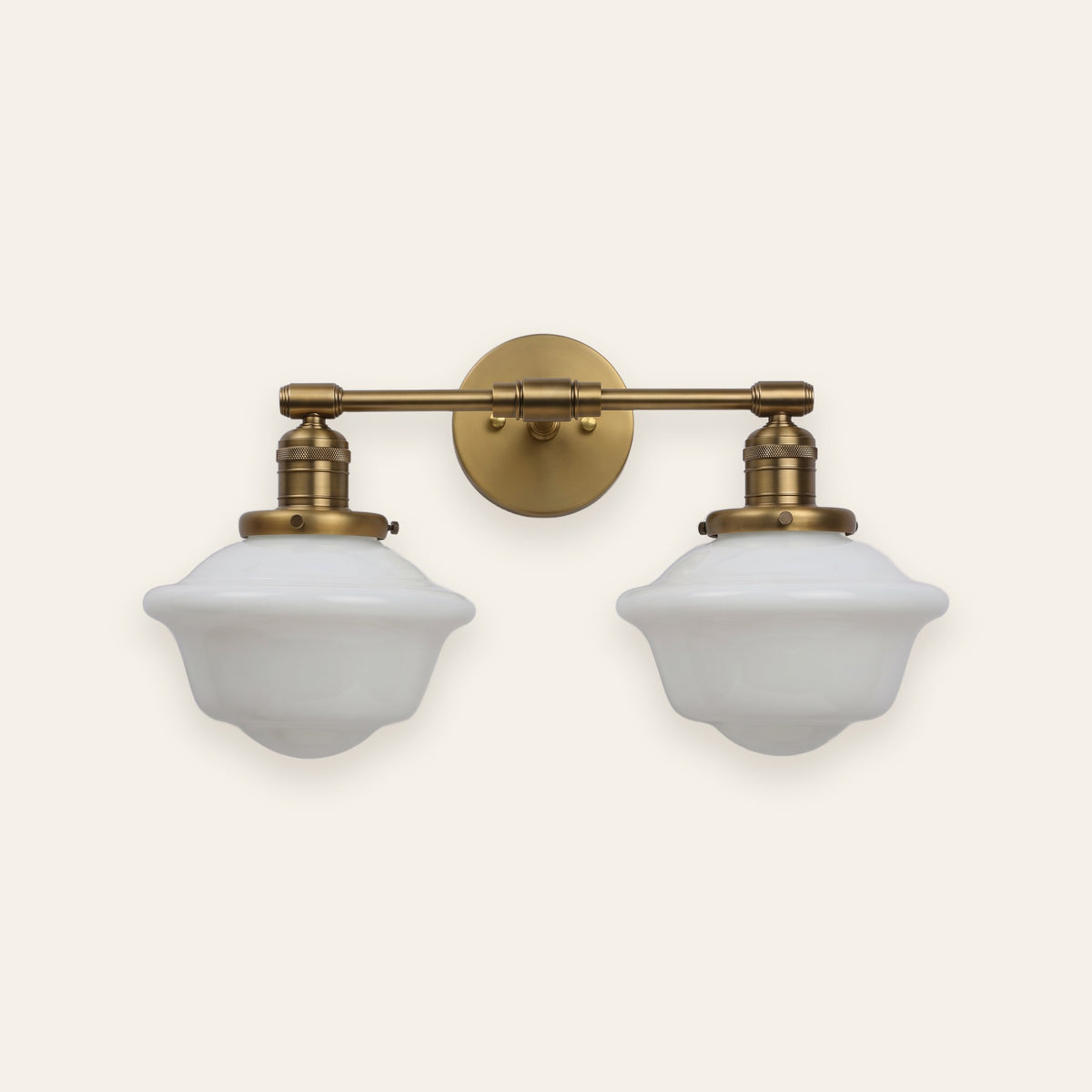 Ely two light milk glass vanity light in antique brass finish on a cream background
