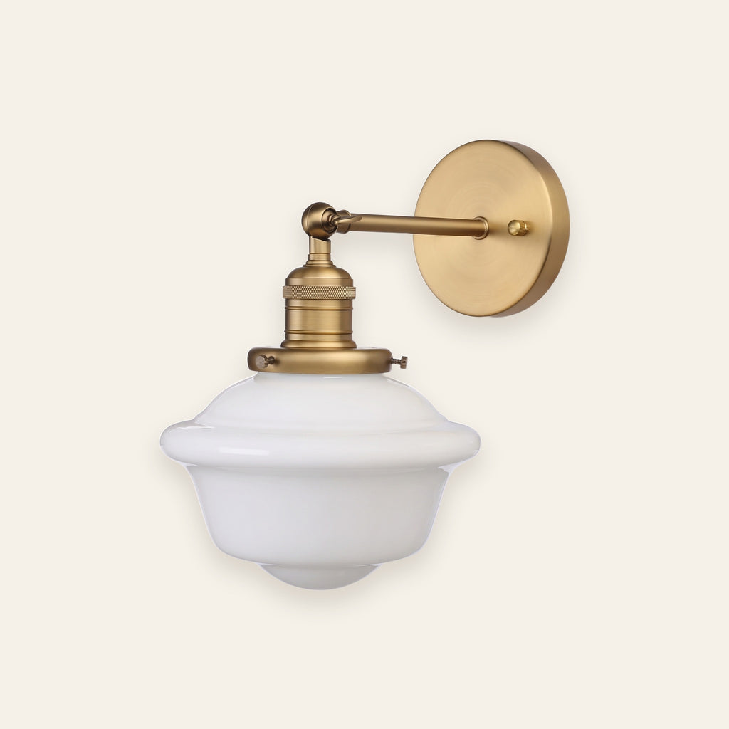 Ely milk glass wall light in antique brass finish on a cream background