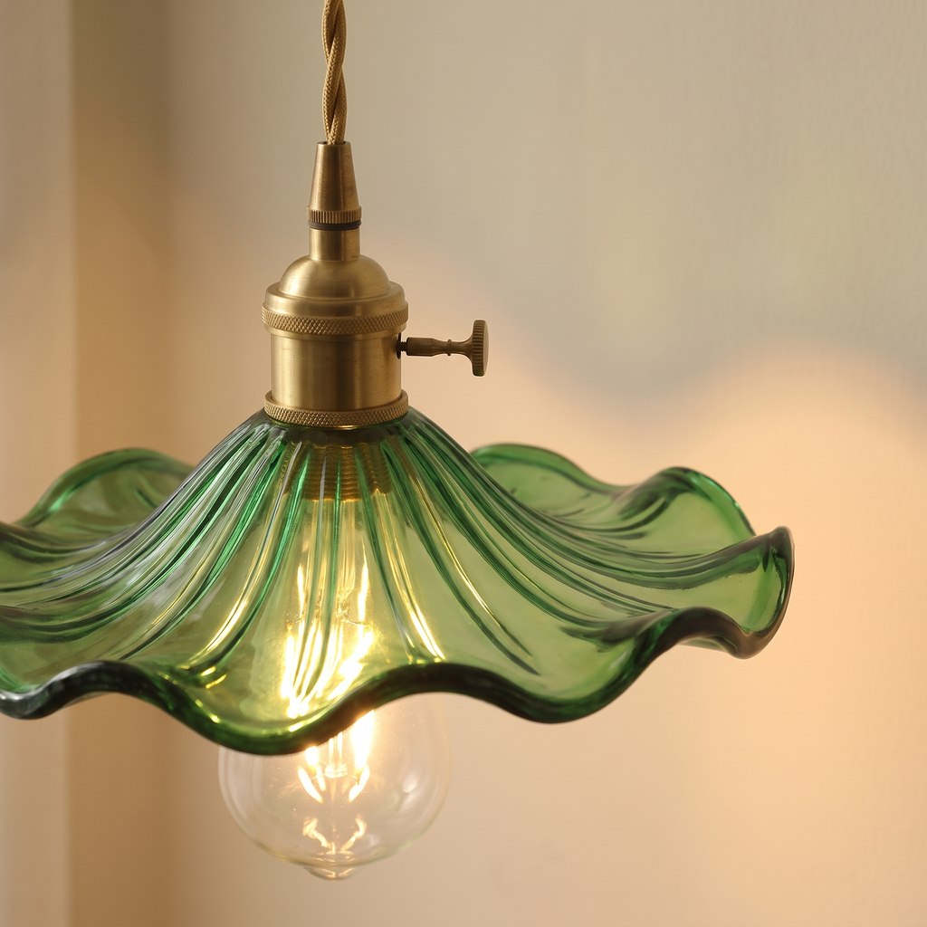 Close up of the lit green Framlingham pendant: veined lotus leaf glass with a ruffled rim and the bulb below