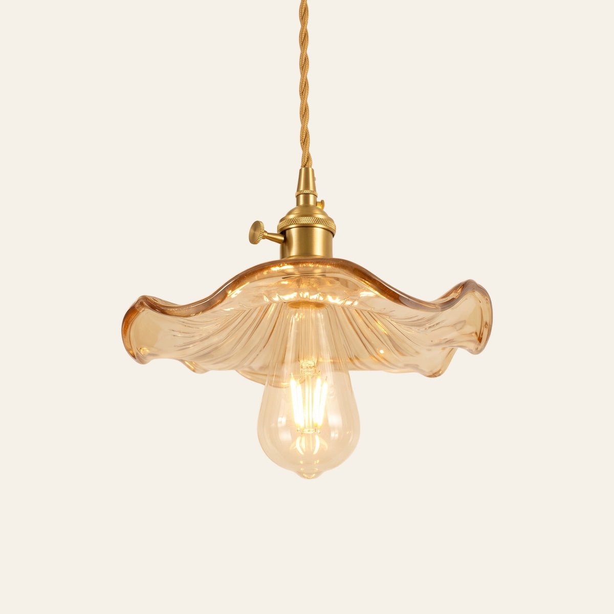 Framlingham lotus leaf glass pendant light in amber glass with the bulb below, brass holder, cream background