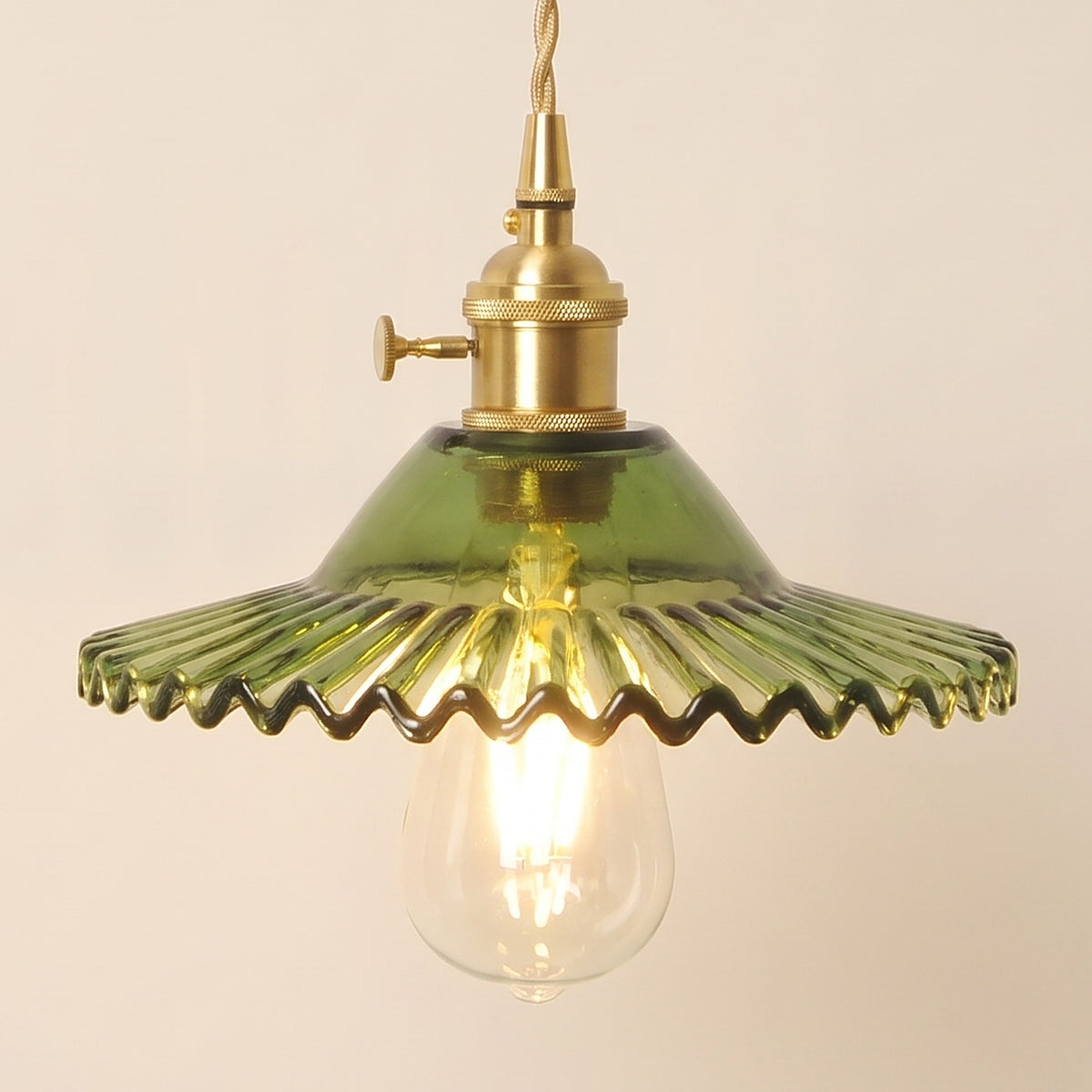 Close up of the lit green Glemsford shade: fine flutes running out to a crimped edge above the bulb