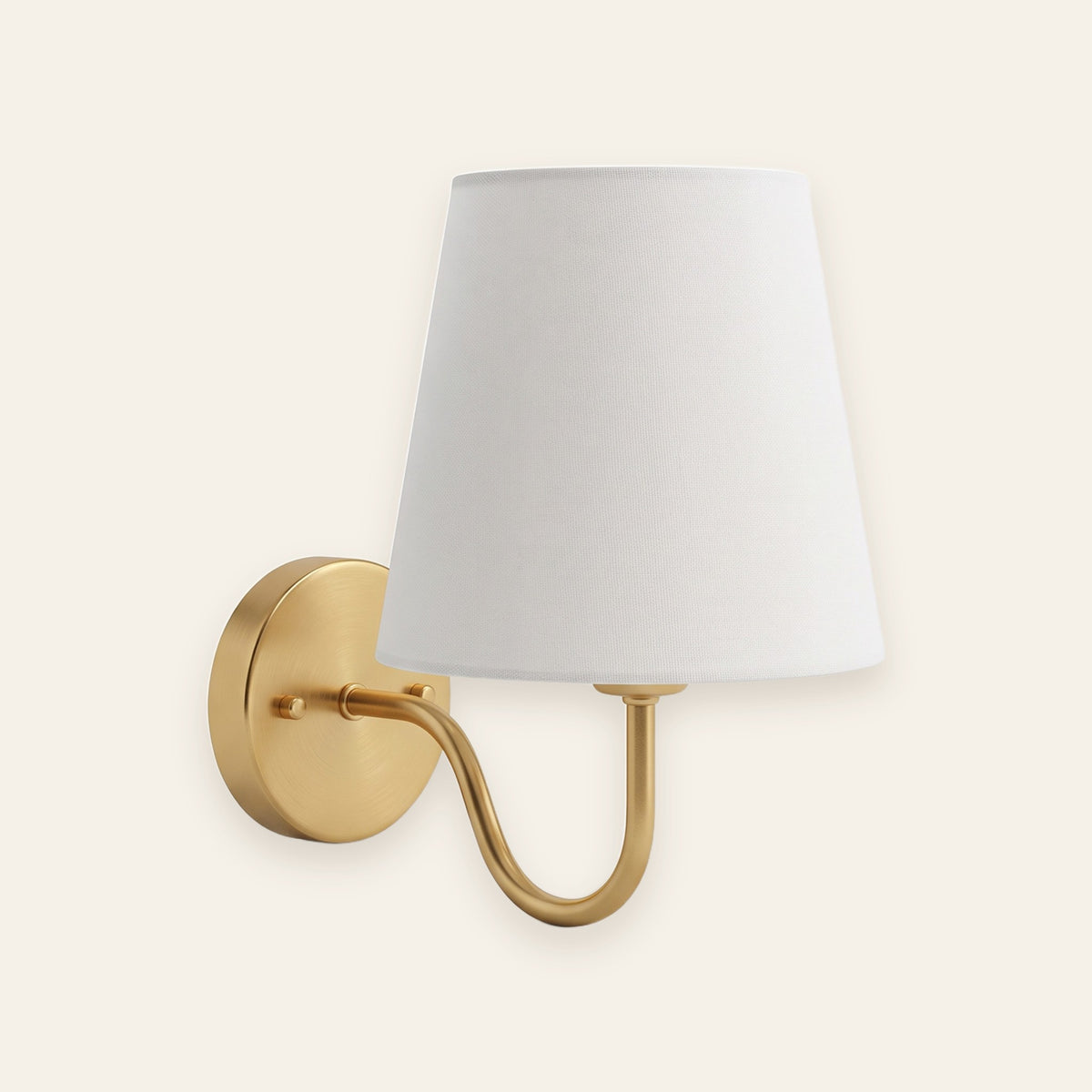 Halcombe brass wall light with white fabric shade on a cream background