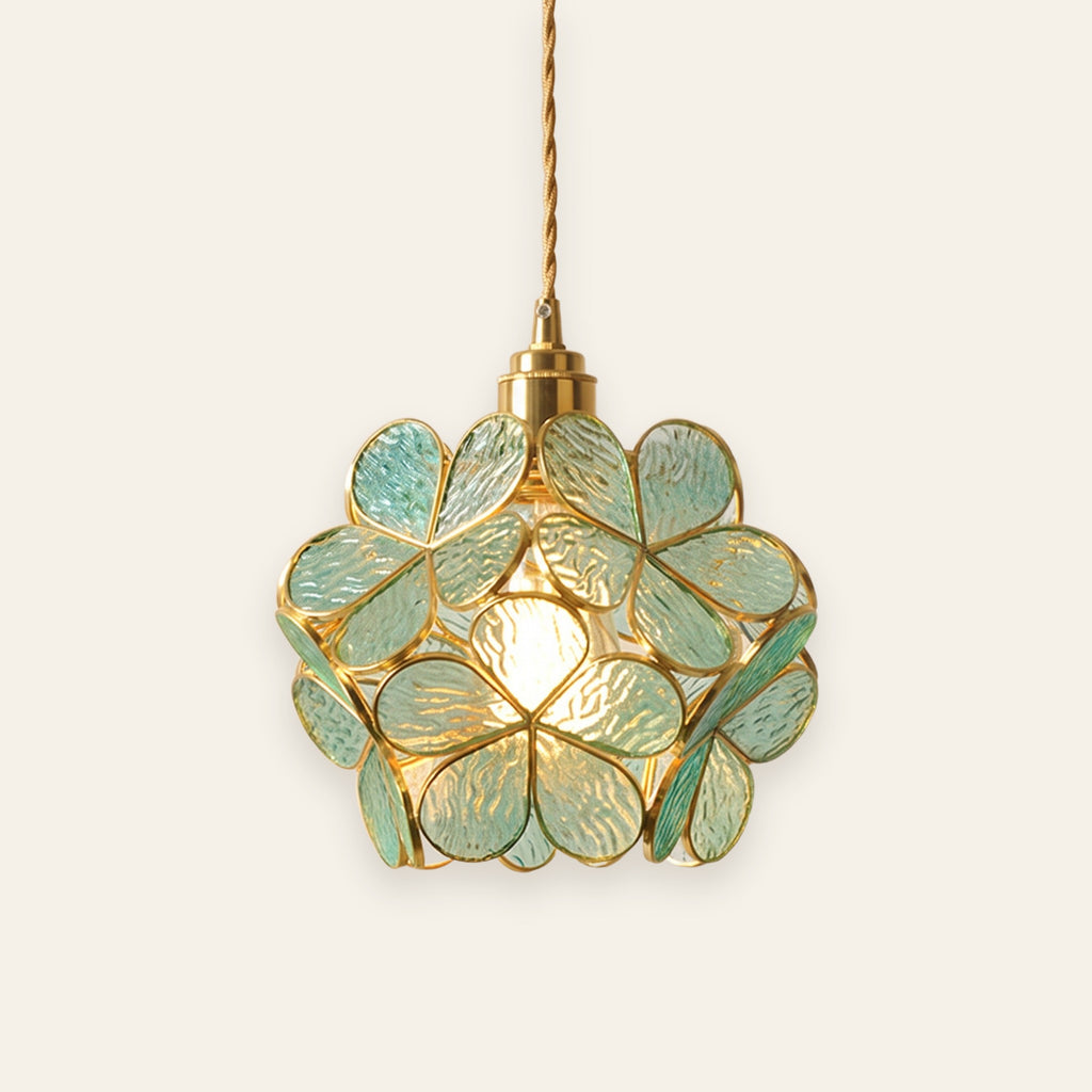 Halesworth pendant light with a round shade of sea green textured glass petals edged in brass, lit