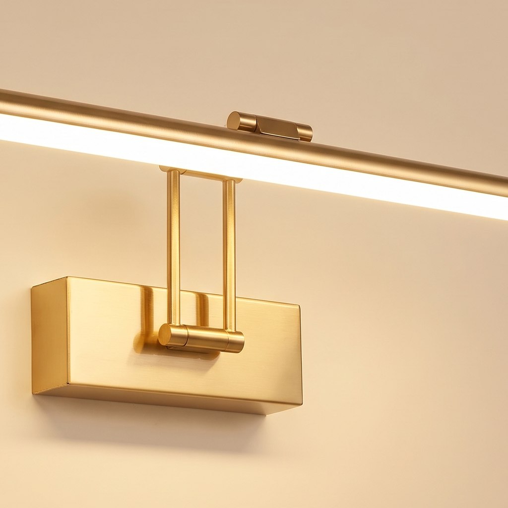 Close up of the brushed gold Helmingham picture light: the slim tube bar, its glowing diffuser, the arms and the wall box