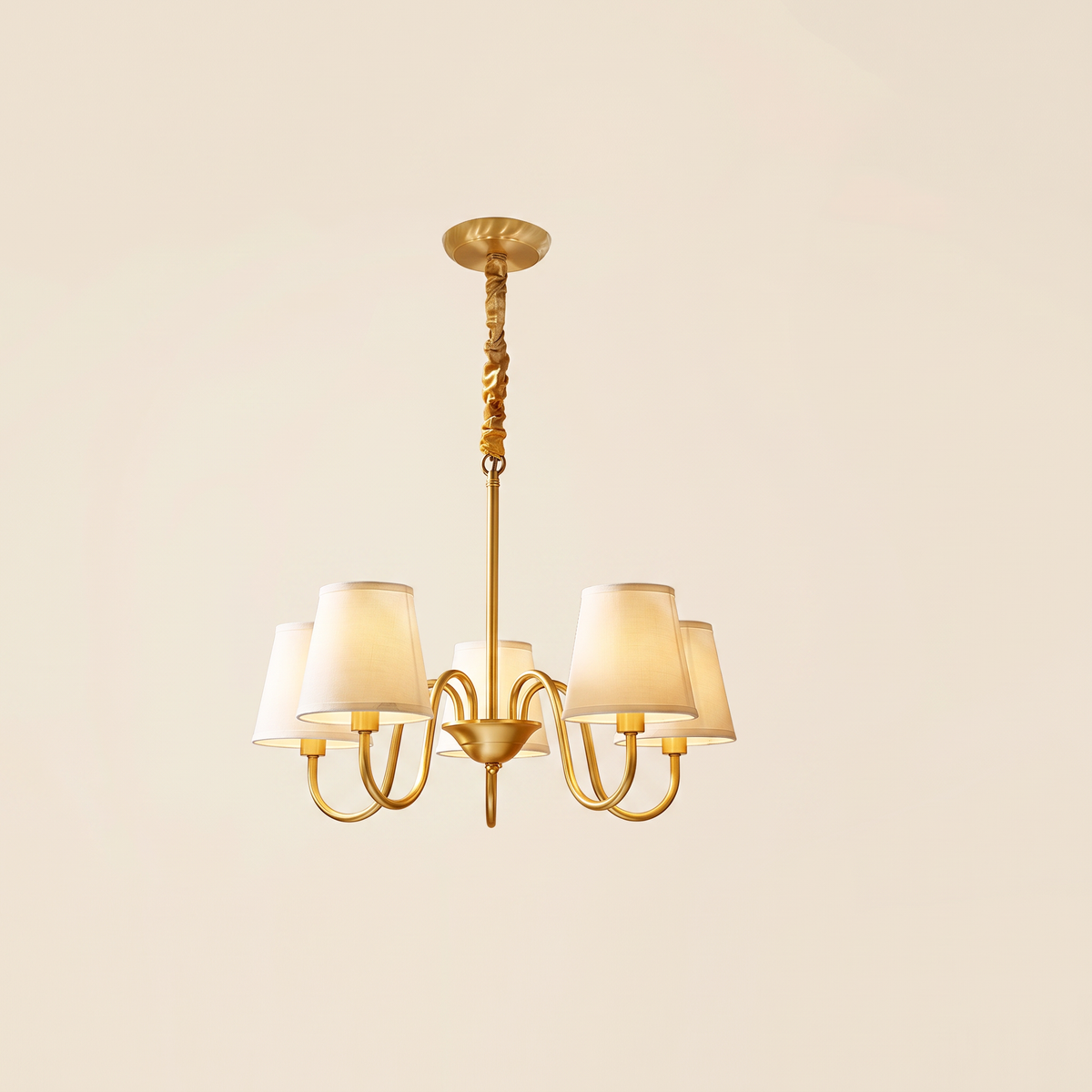 Henham 5 arm brass coloured chandelier with cream linen shades, lit, cream background