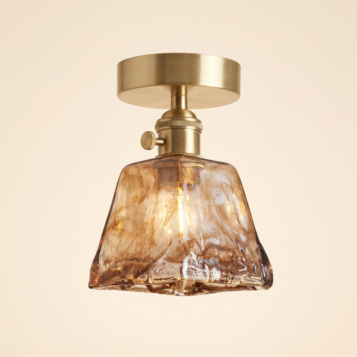 Heveningham semi flush ceiling light with a square smoky amber ice glass shade on a brass holder with a turn switch, cream background