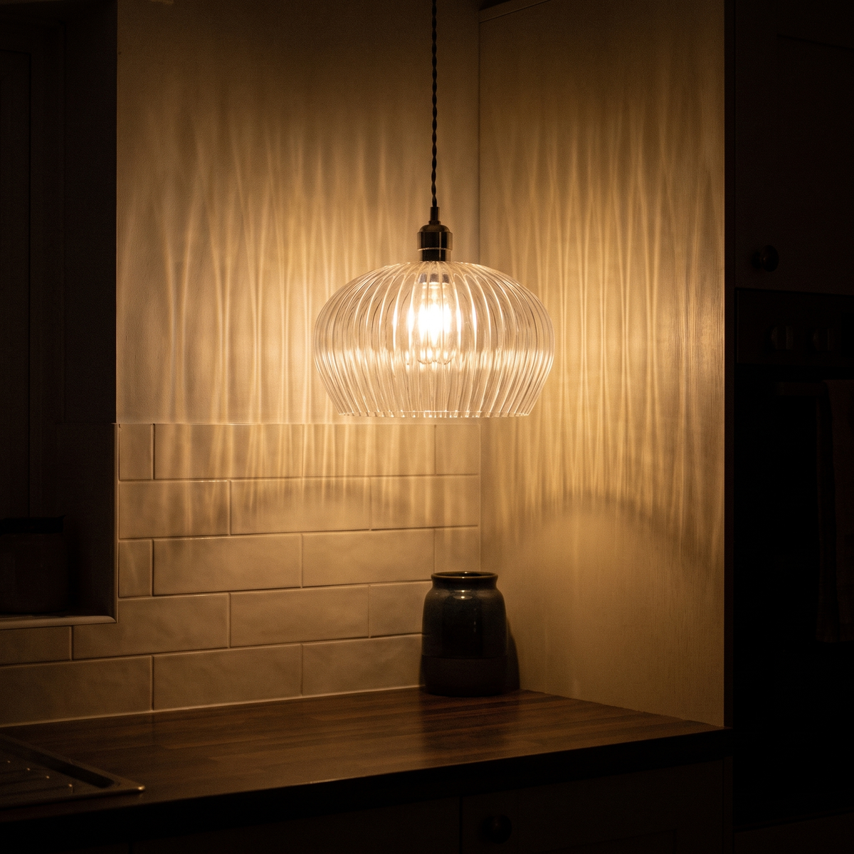 Sereno pendant light lit above a kitchen worktop in the evening