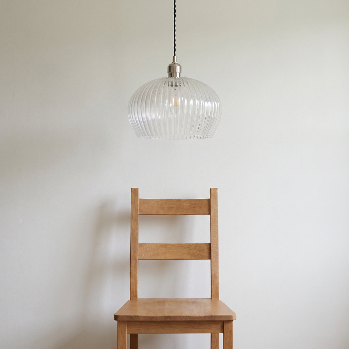 Lumira pendant light shown above a dining chair for size reference