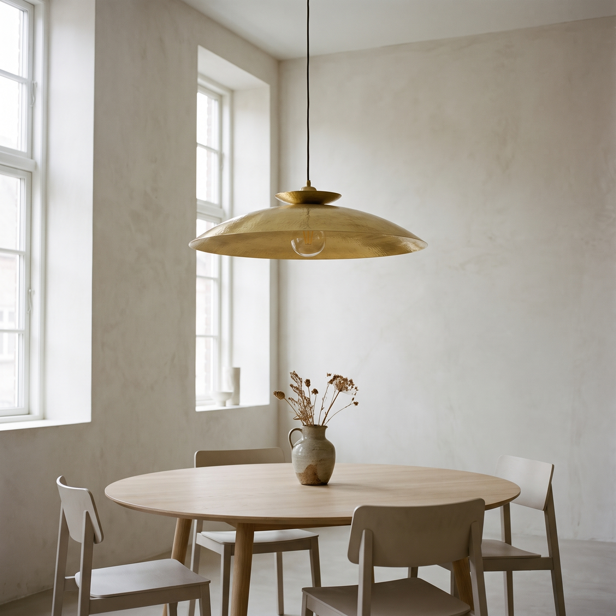 Halvern oversized brass disc pendant above a round dining table