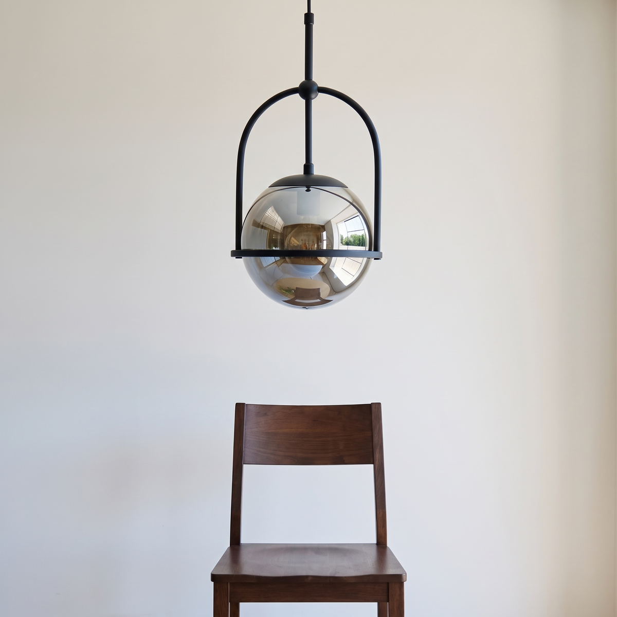 Noctis pendant light shown above a dining chair for size reference