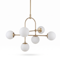 Aurelle antique brass six light chandelier with opal glass globes on a white background