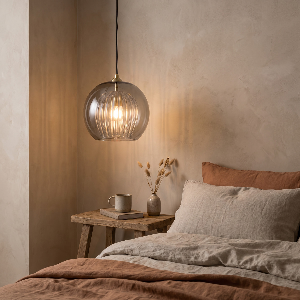 A Corran pendant hanging low beside a bed