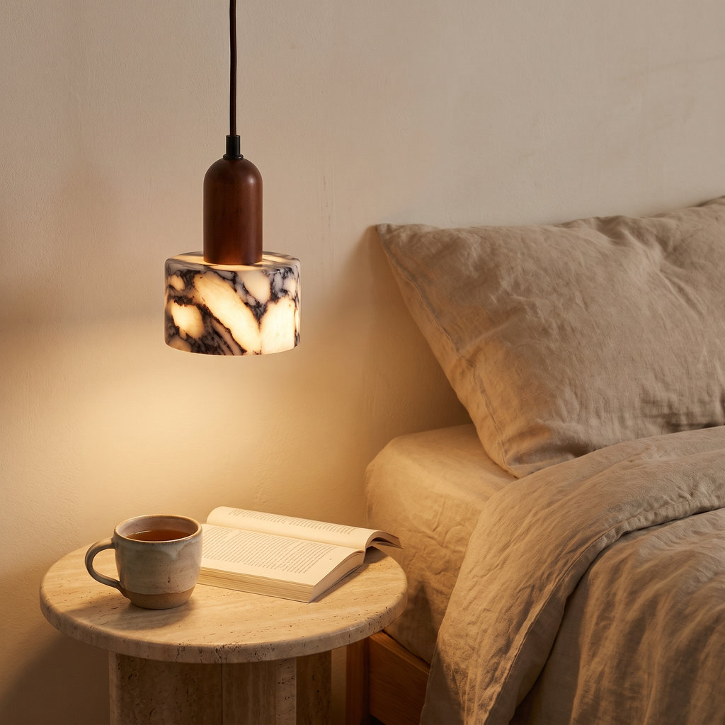 Carrow marble pendant hanging low beside a bed