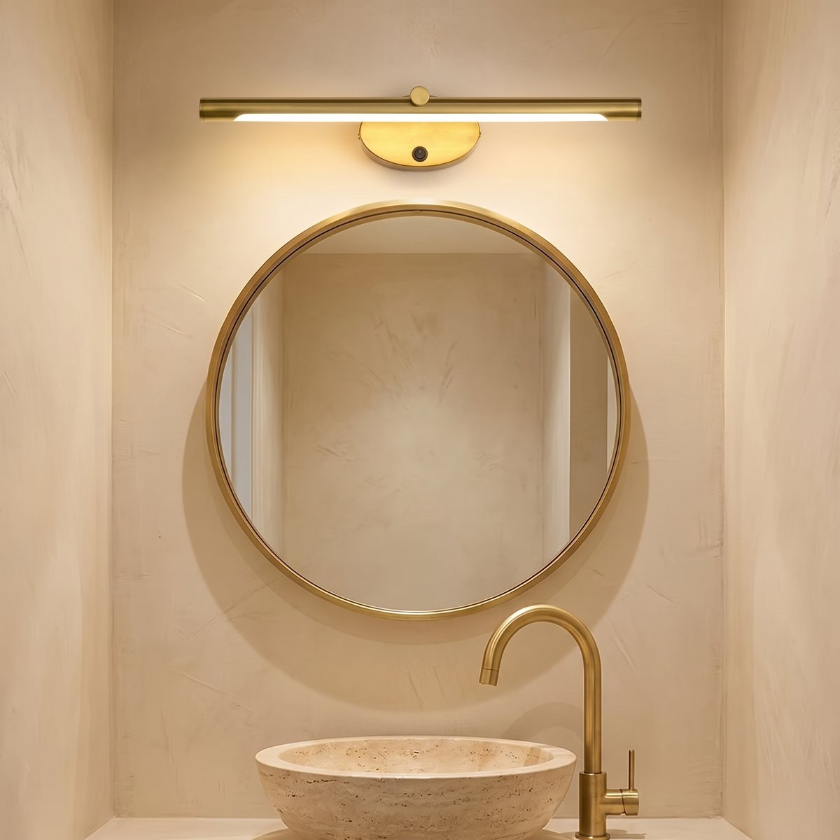 Halden gold vanity light above a round brass mirror and stone basin