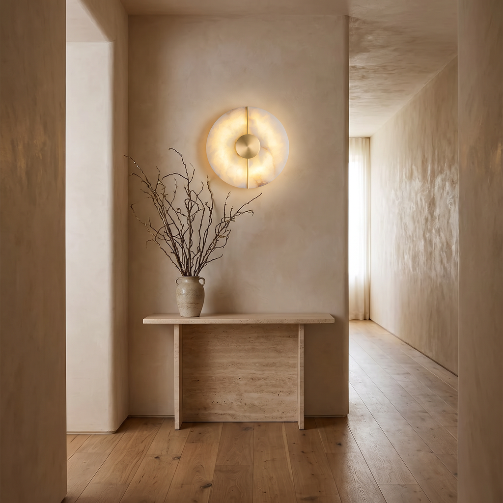 Avebury alabaster wall light above a travertine console in a hallway